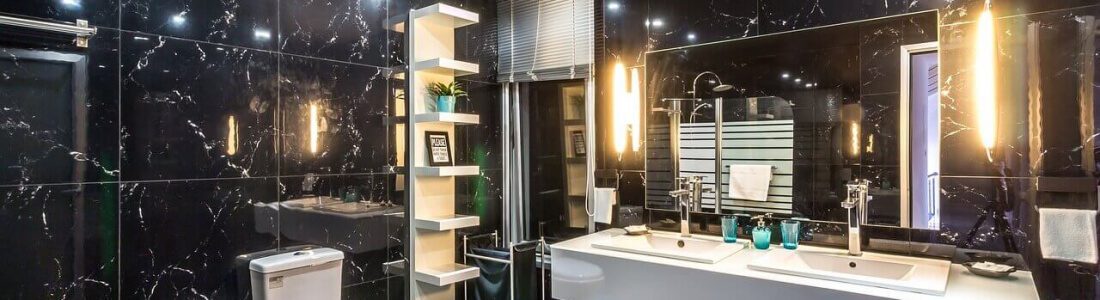 a white bathroom vanity against black marble walls